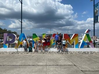 a group of students stand in front of a sign that reads "Panama"