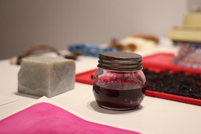 a jar of blackberry juice on an art studio desk