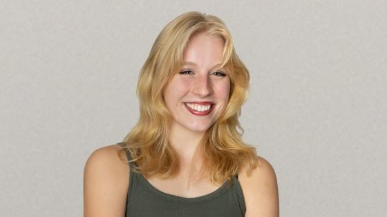 a young white woman with blonde hair wearing a green tank top