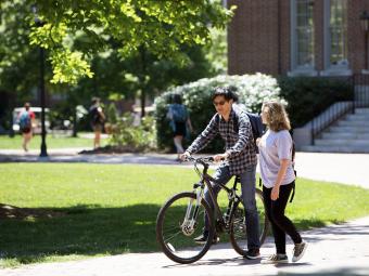 Students talk with one on bike