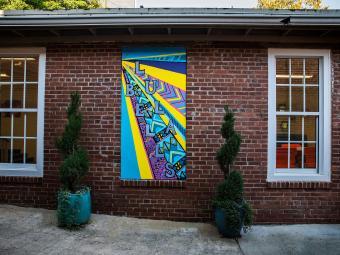 Lula Bell's entryway with graffiti mural and planters against brick exterior