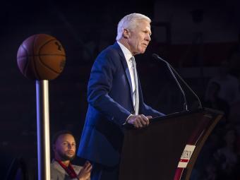 Steph Curry looks on as Coach McKillop speaks during Curry for 3 Event