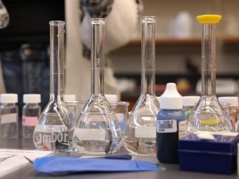 a table covered with glass beakers in a lab
