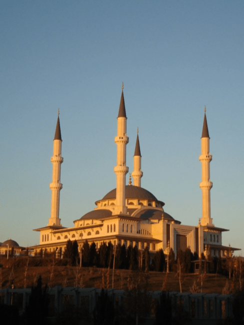 a large mosque set on a blue sky background