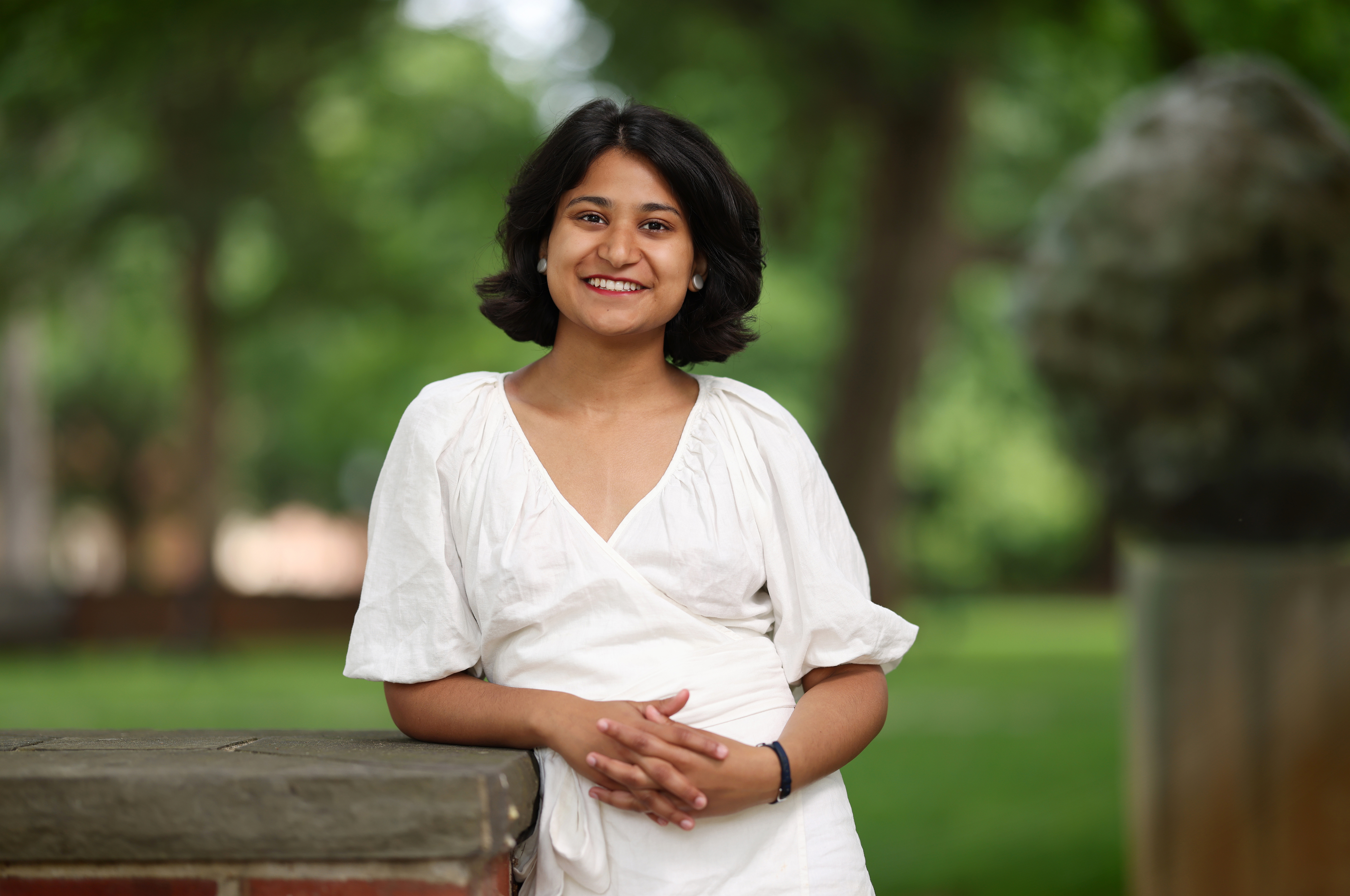 a young woman wearing white standing on a campus