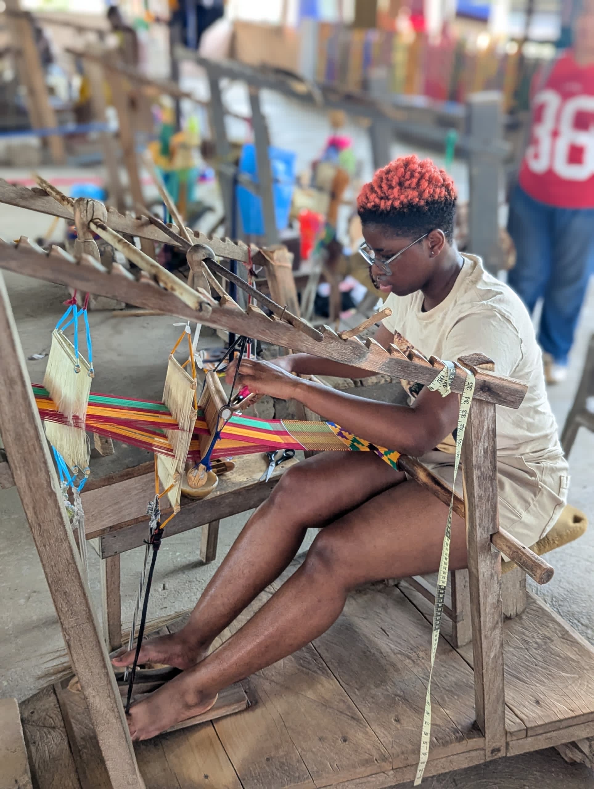 a young person works at a loom 