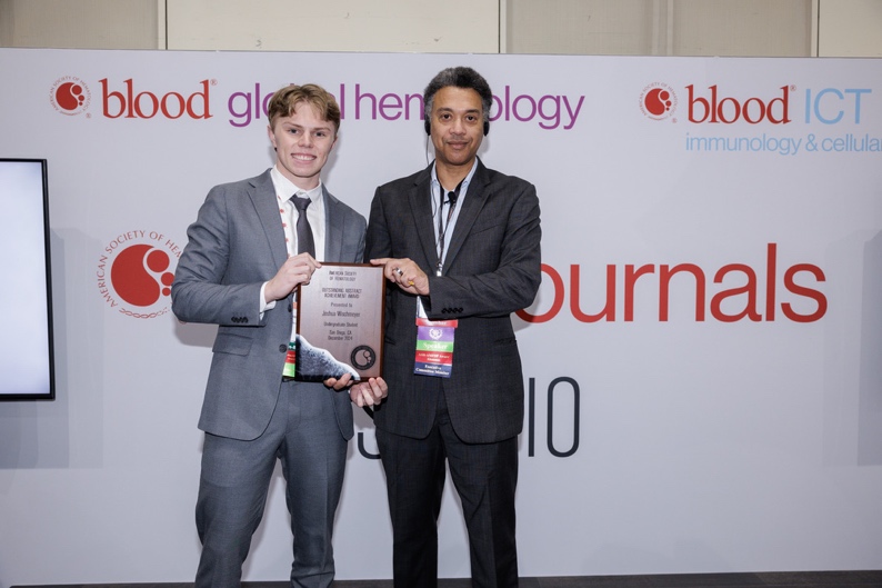 Joshua Wischmeyer, a junior biology major from Denver, Colorado, receiving award