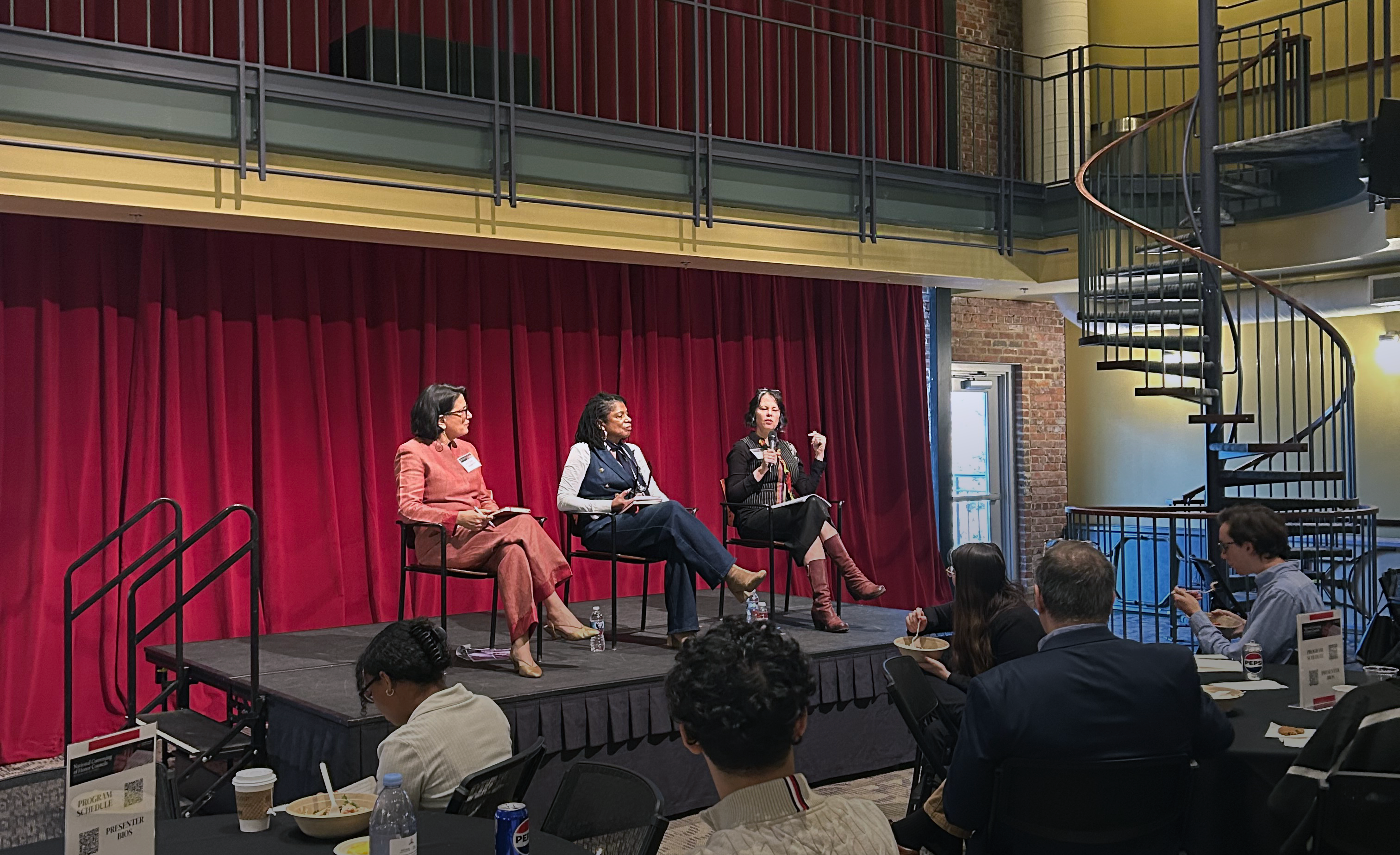 Three female panelists sit onstage in the 900 room on Davidson's campus