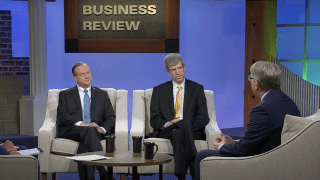 a group of three older white men sit around a TV set talking