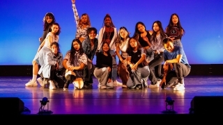 a group of students pose together after a dance performance on stage