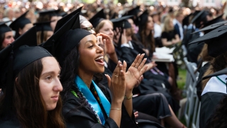 Student smiles and claps at Commencement 2026
