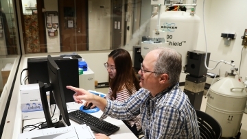 Prof. Blauch and Student working with large chemistry equipment