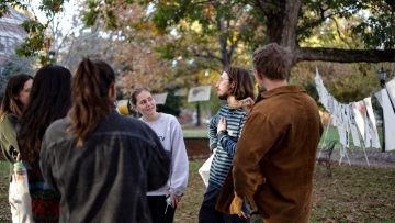 Students in a group outside, surrounded by papers on clotheslines
