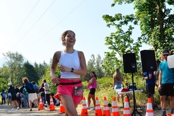 a young woman wears athletics while running a road race
