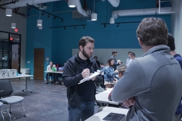 adults and students talk to each other in an innovation center