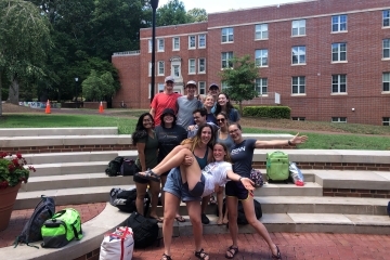 a group of students standing on brick stairs outside on a college campus