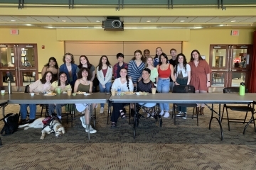 a group of students sit behind a table as part of an event