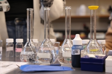 a table covered with glass beakers in a lab
