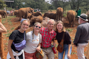 a group of people standing in front of an elephant enclosure