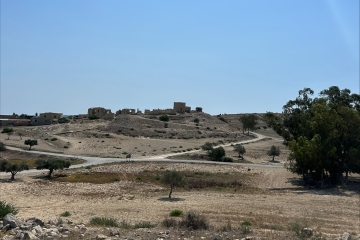 a view of rolling hills with a blue sky in the background