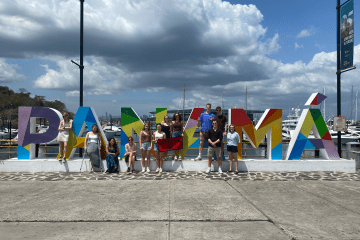 a group of students stand in front of a sign that reads "Panama"