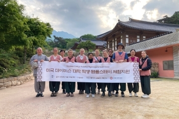 a group of students and adults standing together in front of a Buddhist temple