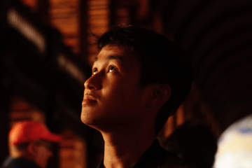 a young man in a dark setting looking up