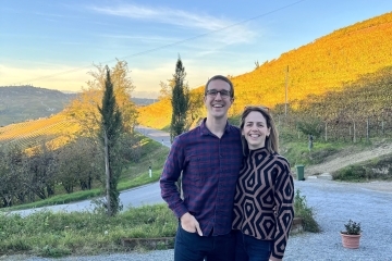 a young couple standing in front of a mountainside