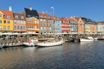 a view of historic Copenhagen - colorful houses and boats along a river