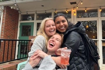 a group of young women smiling and holding a coffee