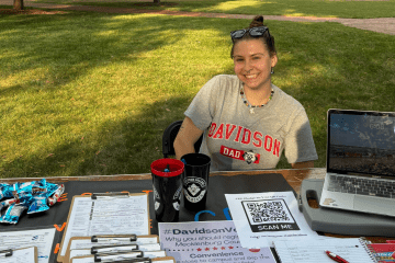 a young woman smiling sitting at a table