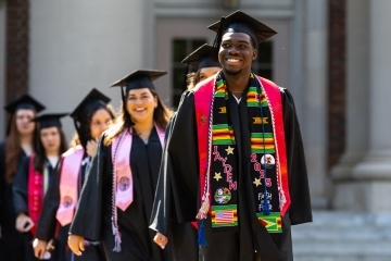 Commencement 2025 students smiling in procession 