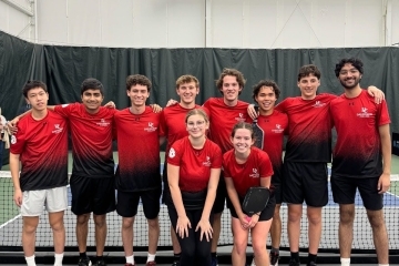 a group of pickleball players on an indoor court wearing red uniforms