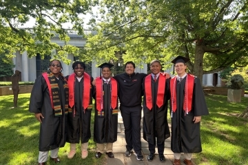 Julian Rawlins ’25 with colleagues at graduation