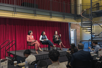 Three female panelists sit onstage in the 900 room on Davidson's campus
