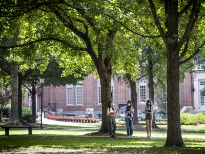 Students Conducting Binocular Experiment on Campus Surrounded by Trees