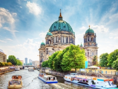 an old church on an island surrounded by boats in a river