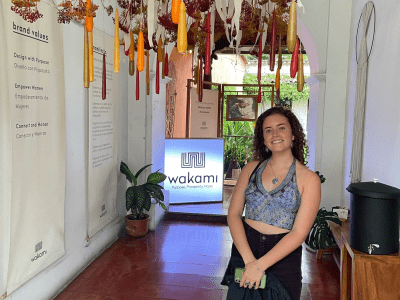 a young woman standing in a museum with art hanging from the ceiling
