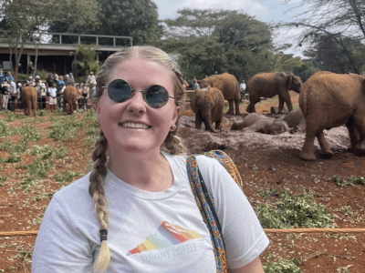a young white woman wearing a tshirt and sunlgasses outside