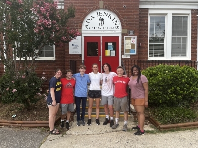 a group of students standing together in front of a brick building that reads "Ada Jenkins Center"