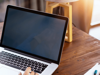 a person working on a laptop with a notebook to the side
