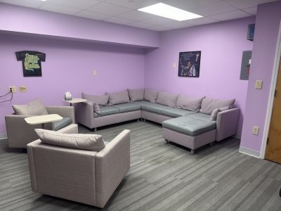 a purple painted room with comfy couches and chairs