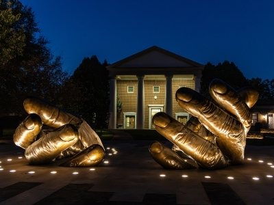 With These Hands Memorial illuminated at night