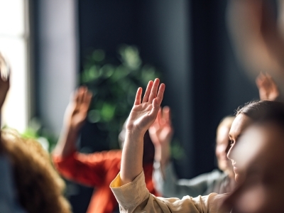 Blurry hands raised in an educational setting