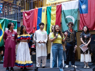 International Association Student Day on stage with flags in the background