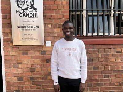 Branton Mogeni in South Africa in front of a building on a trip he went on through Dean Rusk