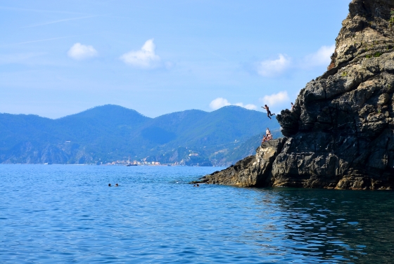 Ocean meets a cliff where a boy cliffdives in Sienna