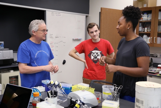 Prof. Campbell with two students in lab surrounded by laboratory equipment