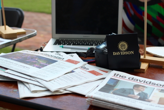 The Davidsonian copies on a table with a laptop and Davidson gear