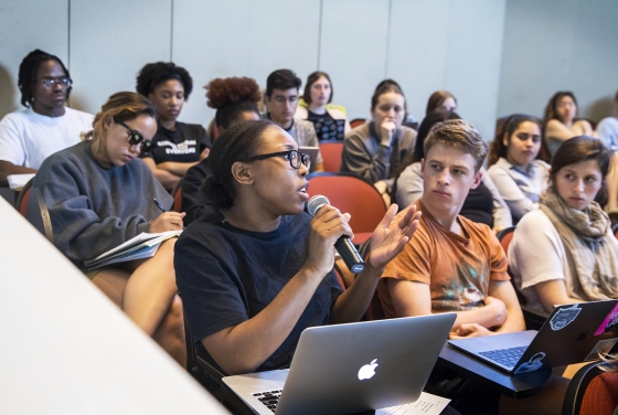 Classroom scene w student speaking at microphone